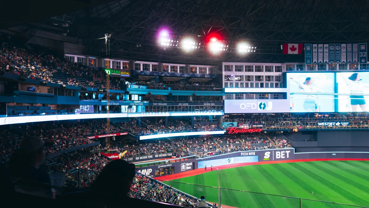BMO Field interior at night with lit scoreboards, a Canadian flag visible in the upper deck, and fans filling the stands in Toronto