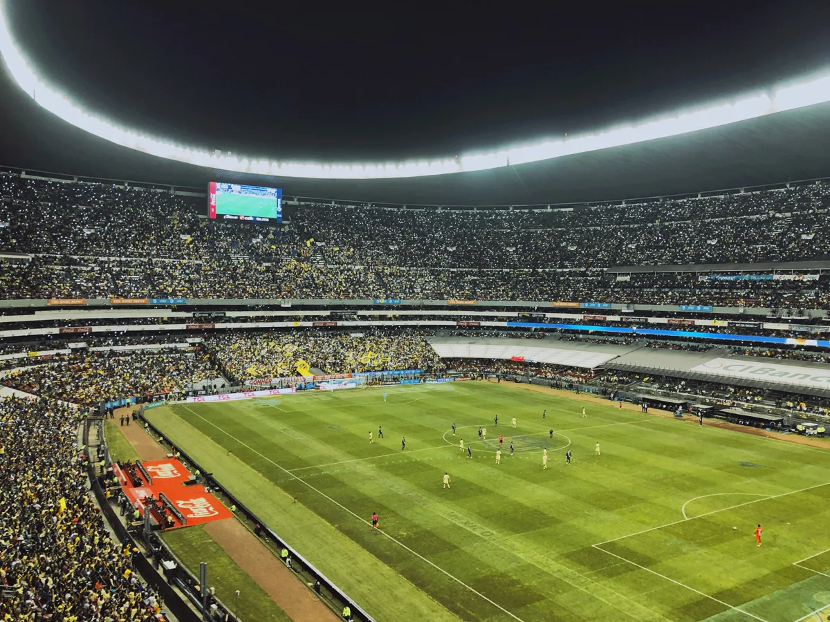 Estadio Azteca interior during a night match with over 80,000 fans in yellow and blue filling the circular stands in Mexico City