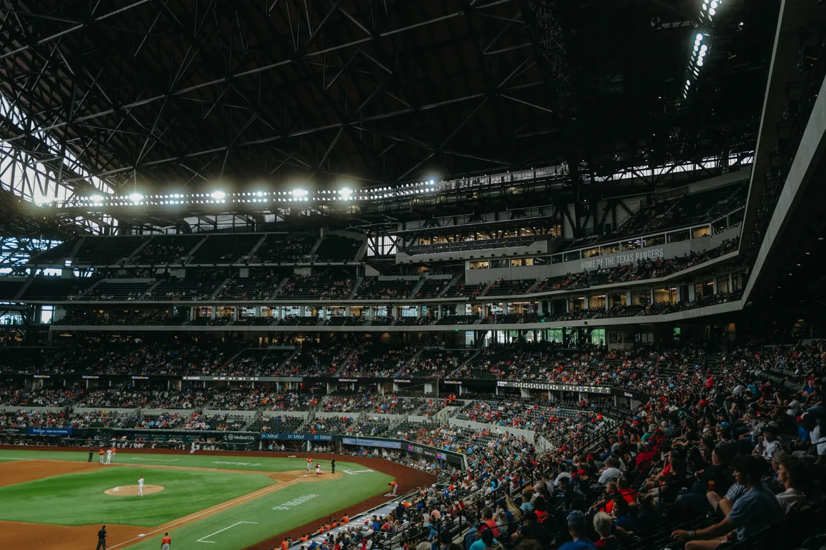 NRG Stadium interior from the upper stands showing the retractable roof structure above a packed crowd at a live event in Houston